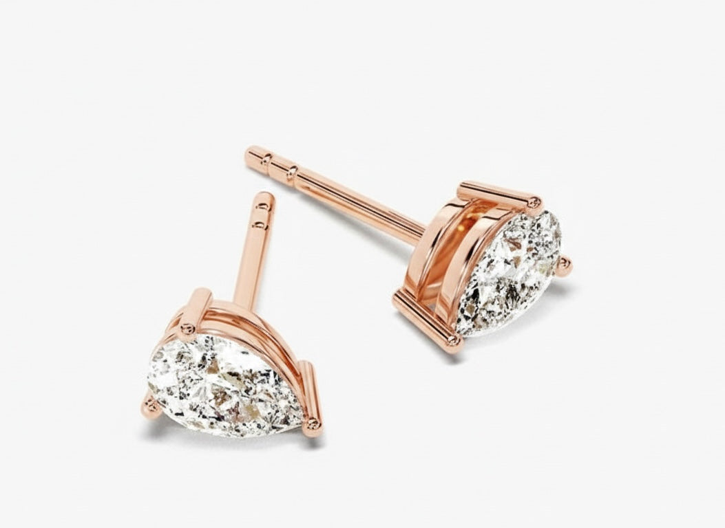 Rose gold earrings with pear-shaped diamond on a white background