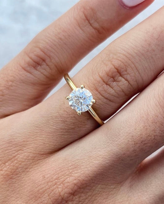 Hand wearing Round solitaire ring in gold with lab-grown diamond showing scale and sparkle