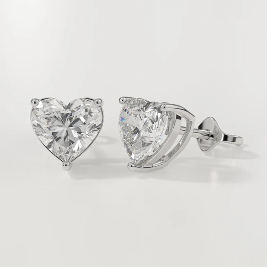 Heart-shaped diamond earrings on a light gray background