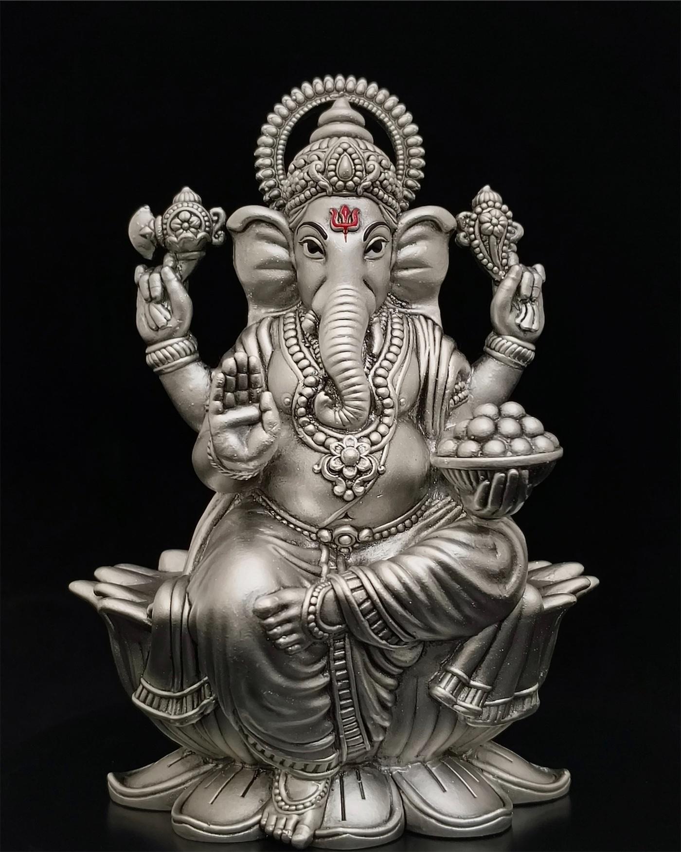 A silver Ganesha, lit on black
