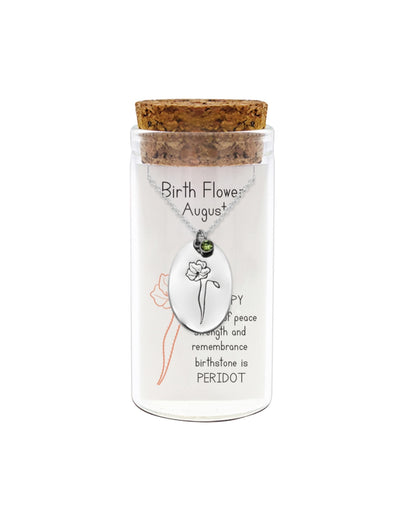 Glass jar with cork lid containing a necklace with a pendant, on a white background