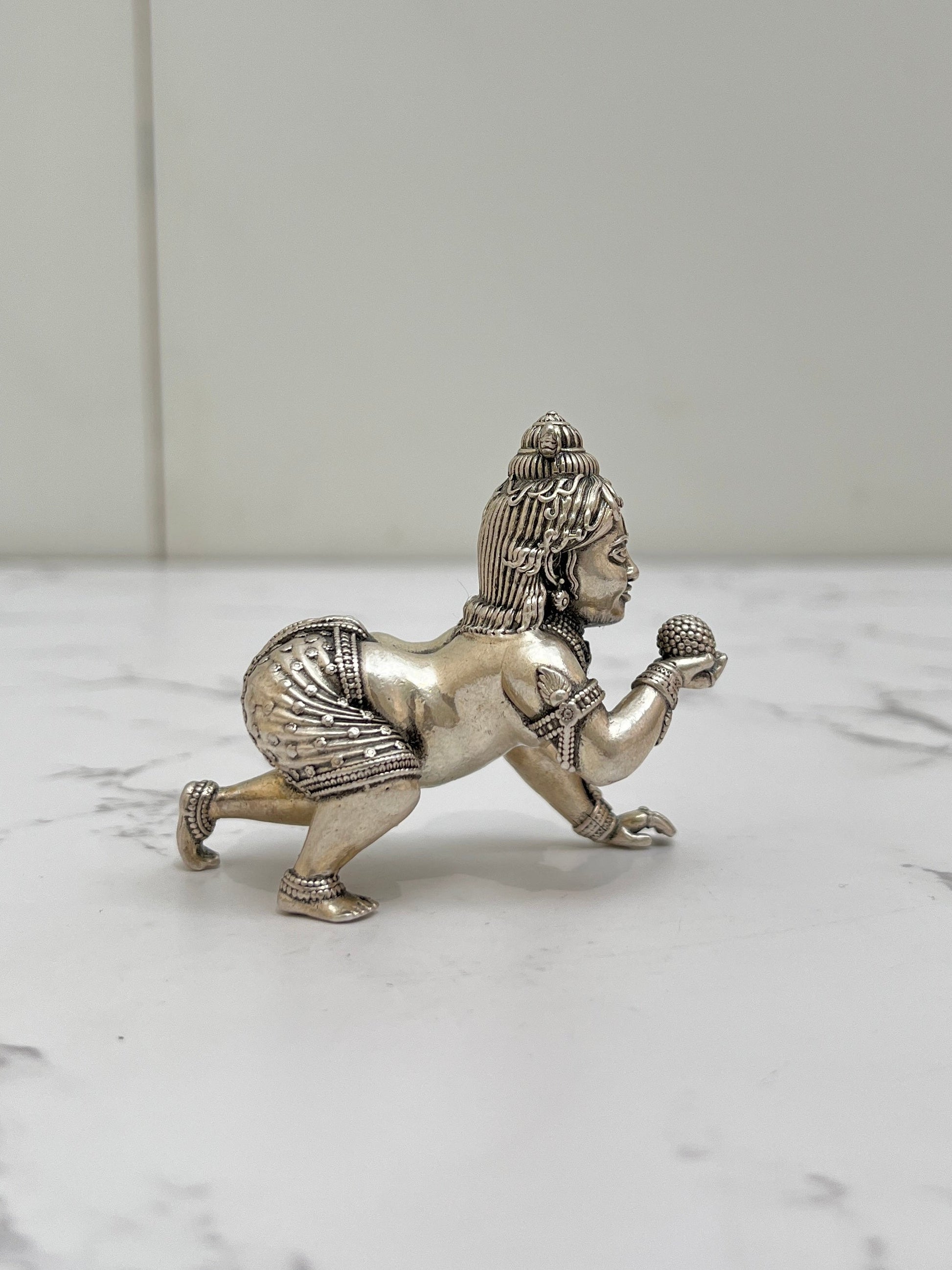Side profile of 925 sterling silver Bal Krishna idol – intricate crown and crawling pose