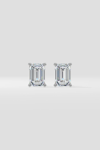 The EMERALD SOLITAIRE EARRINGS feature emerald-cut lab-grown diamonds with VS2 clarity in prong settings, shown against a plain white background.