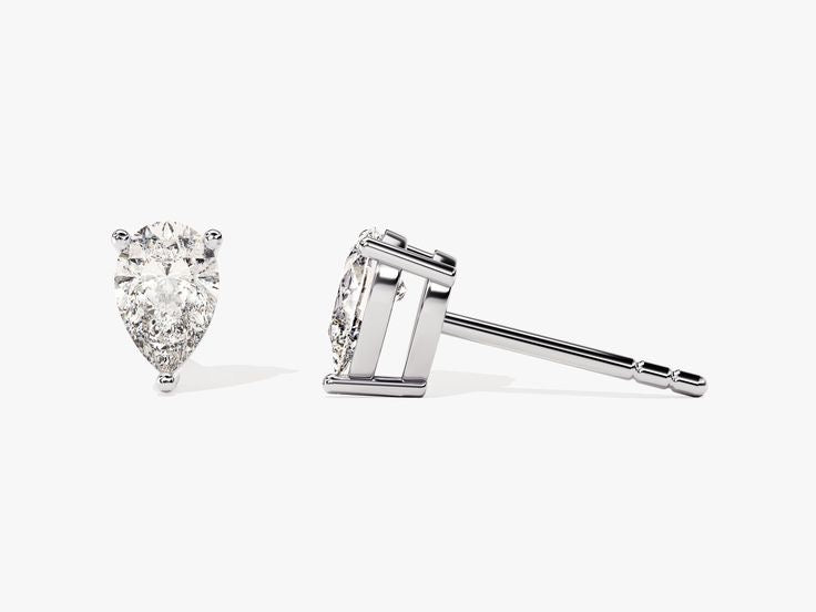 The PEAR SOLITAIRE EARRINGS, crafted in white gold with lab-grown diamonds of VS2 clarity, are shown—one upright to display the gem, the other on its side revealing the post and setting—against a plain white background.