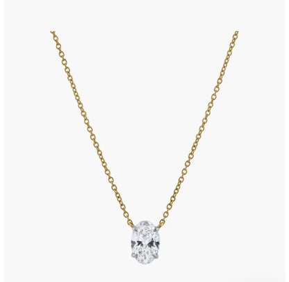 The OVAL SOLITAIRE NECKLACE is a delicate gold oval necklace with a single VS2 clarity lab-grown diamond pendant, shown centered on a plain white background.