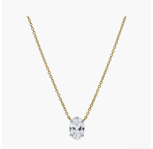 The OVAL SOLITAIRE NECKLACE is a delicate gold oval necklace with a single VS2 clarity lab-grown diamond pendant, shown centered on a plain white background.