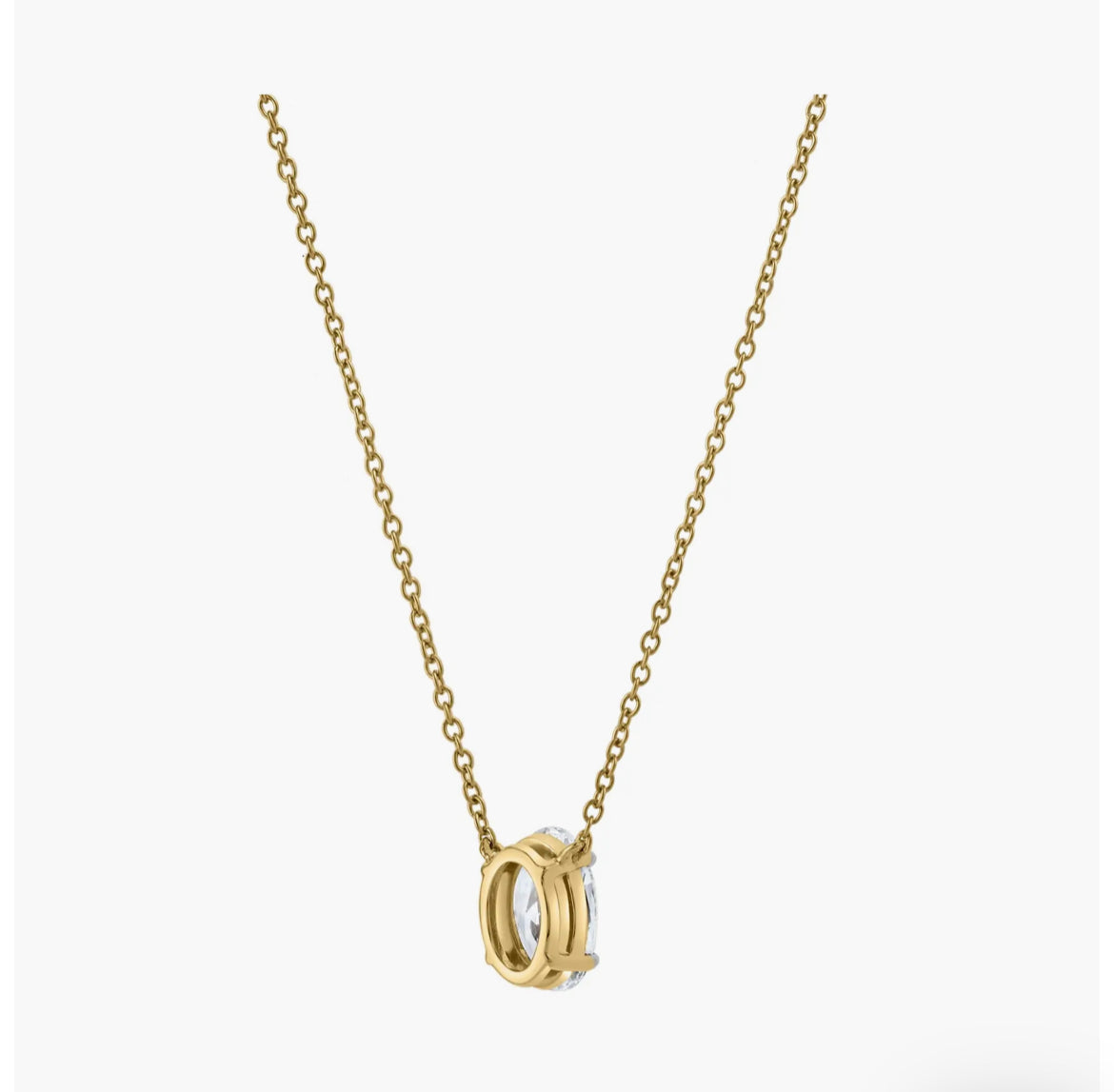 The OVAL SOLITAIRE NECKLACE is a delicate gold chain with a round, two-tone gold and silver pendant featuring an open geometric design and a sparkling lab-grown diamond, shown on a plain white background.