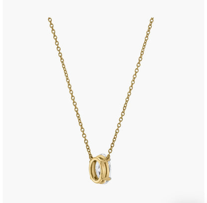 The OVAL SOLITAIRE NECKLACE is a delicate gold chain with a round, two-tone gold and silver pendant featuring an open geometric design and a sparkling lab-grown diamond, shown on a plain white background.