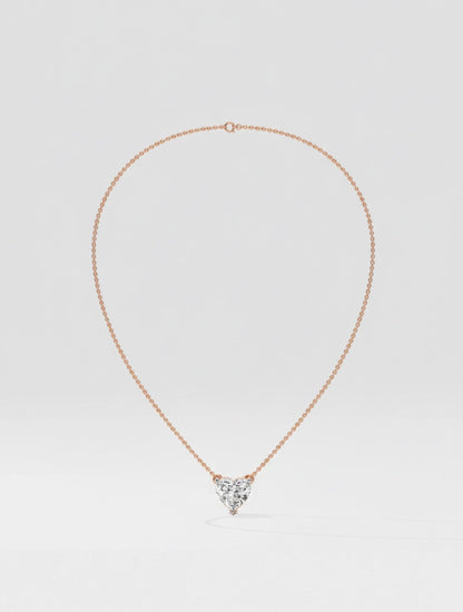 Rose gold necklace with a heart-shaped diamond pendant on a light gray background