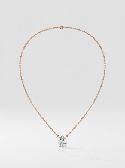 Rose gold necklace with a pear cut diamond solitaire pendant on a light gray background