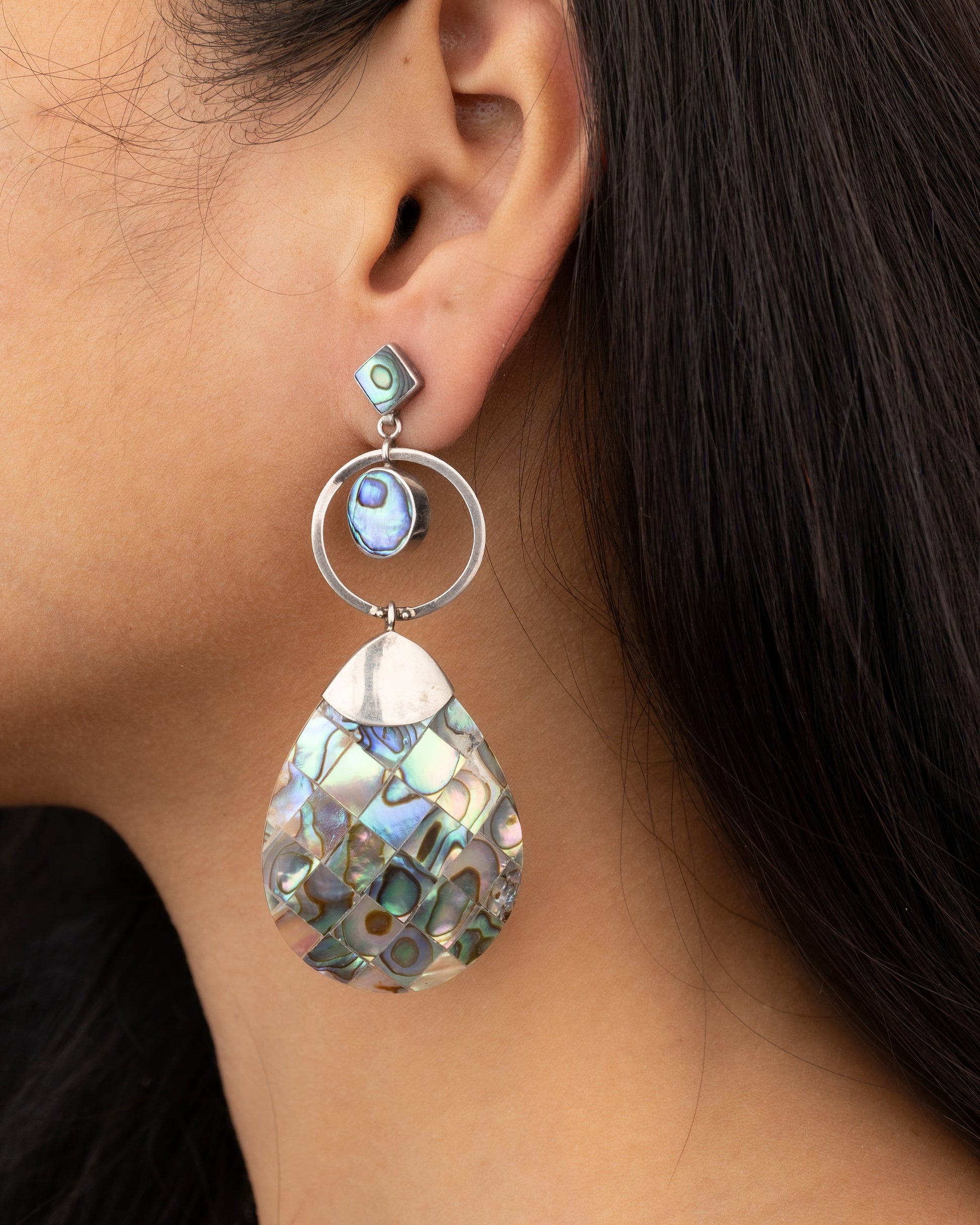 Earring with a teardrop-shaped design worn by a person