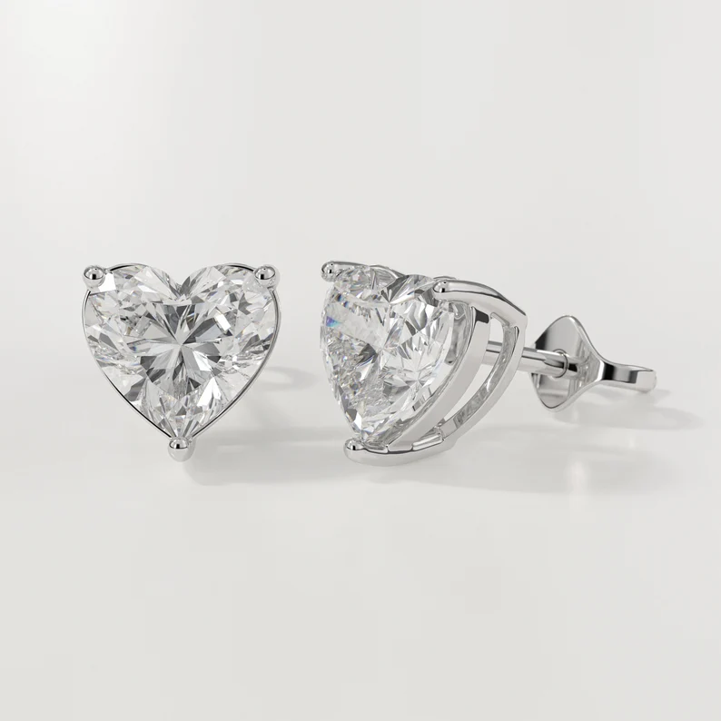 Heart-shaped diamond earrings on a light gray background