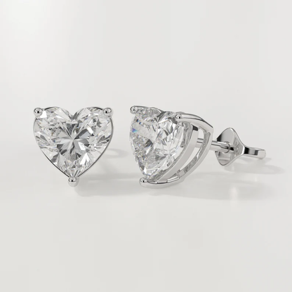 Heart-shaped diamond earrings on a light gray background