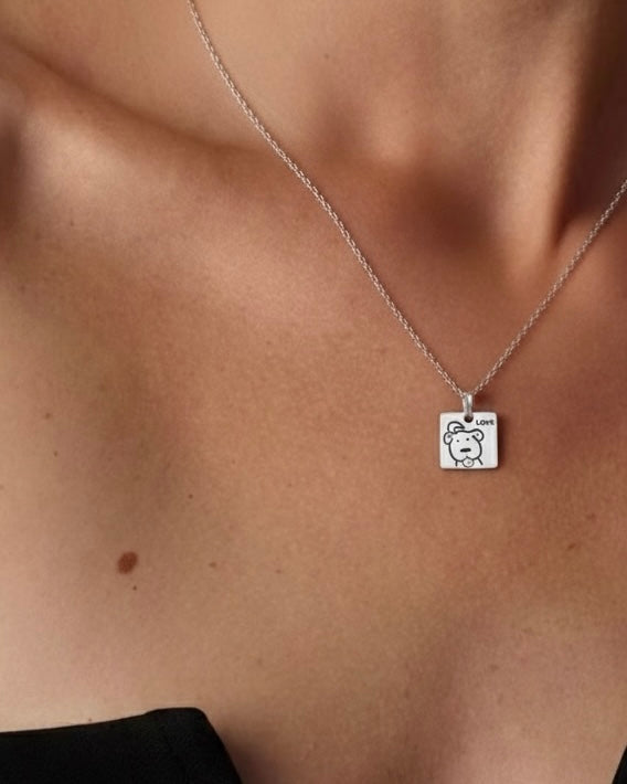 Model wearing cute dog pendant necklace 925 silver – playful woof jewelry on model