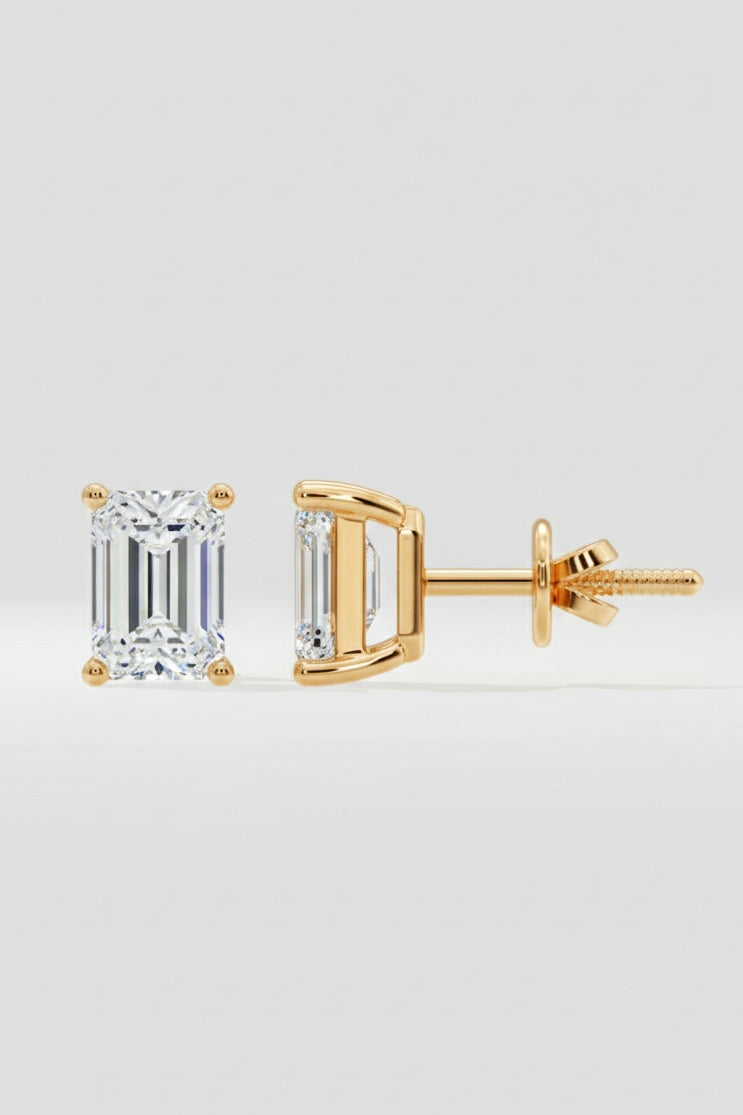 Gold emerald-cut diamond earrings on a light gray background