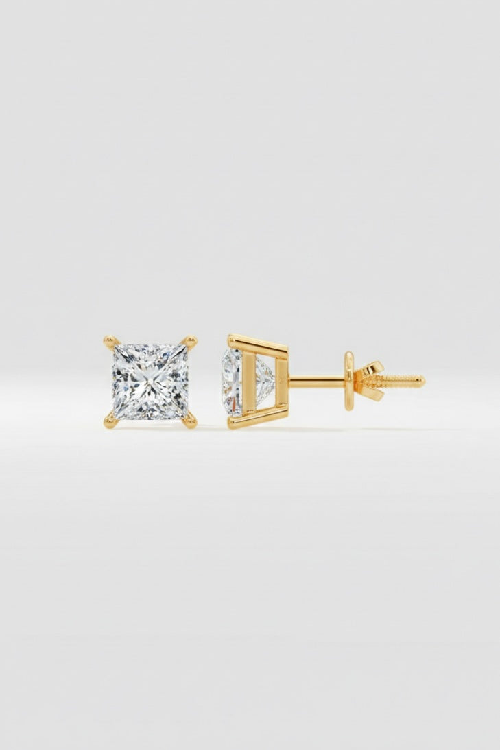 Gold diamond stud earrings on a light gray background