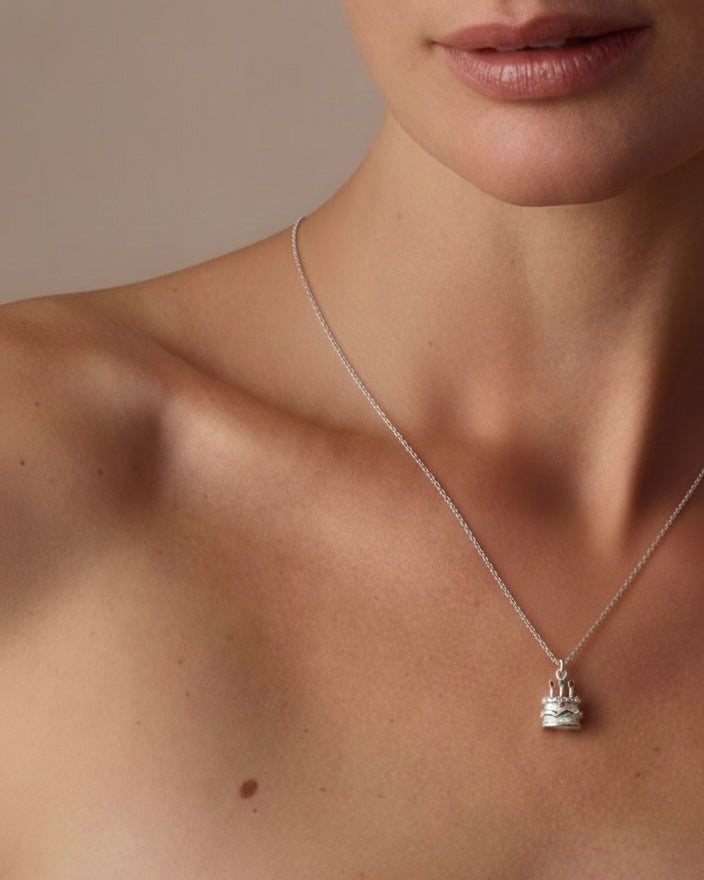 Model wearing birthday cake charm pendant necklace 925 silver – festive cake jewelry on model