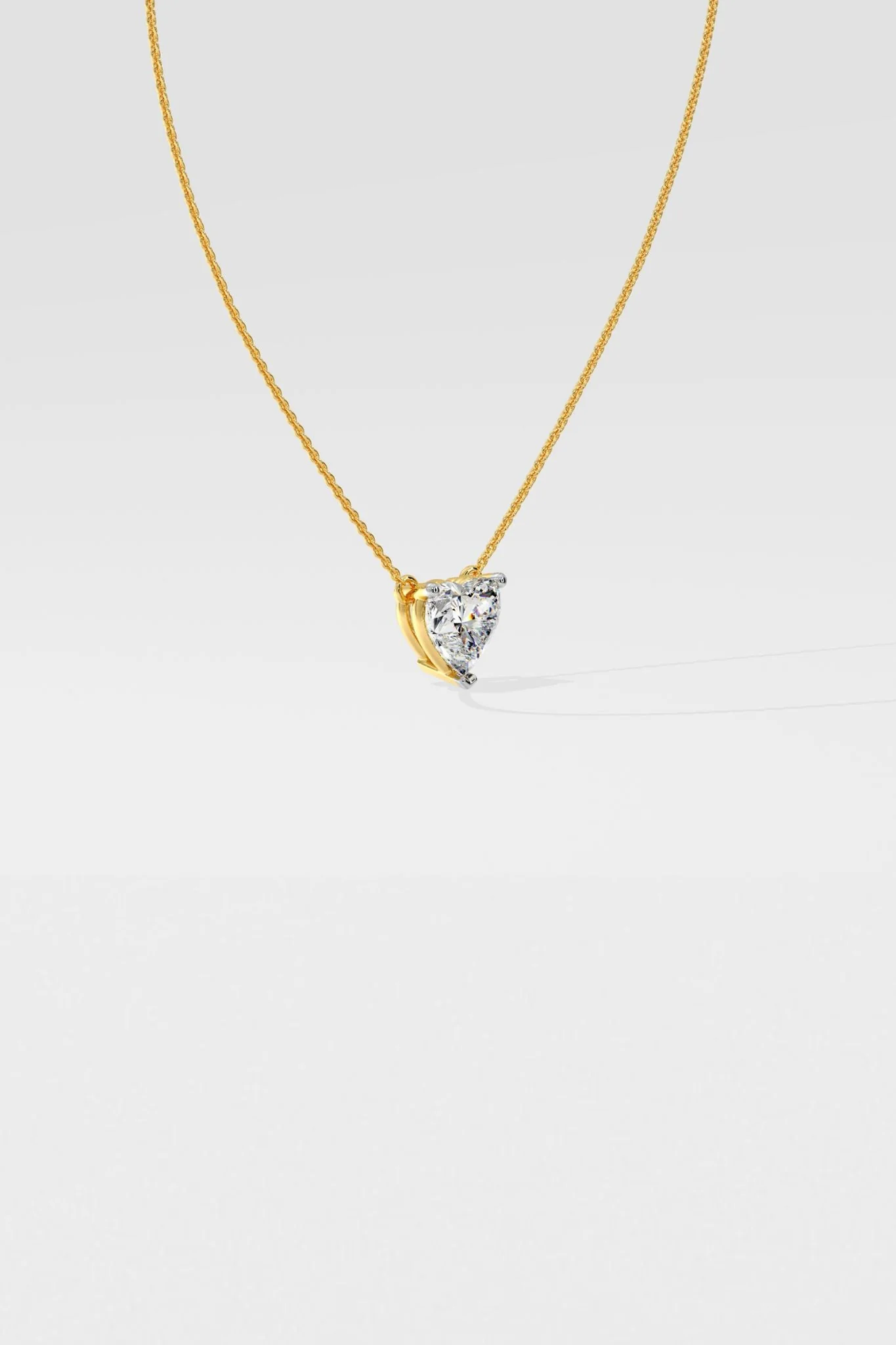 Side profile of custom heart diamond necklace in gold highlighting setting and chain