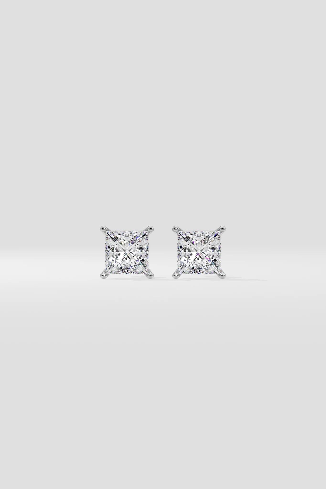 Pair of diamond stud earrings on a light gray background